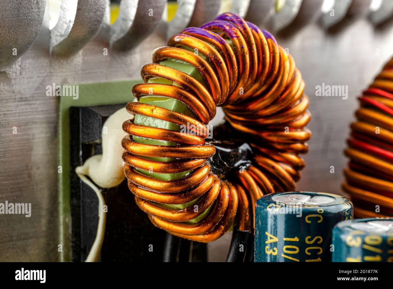 An inductor, toroidal coil on a ring with visible copper scroll, wound on a magnetic coil. Stock Photo