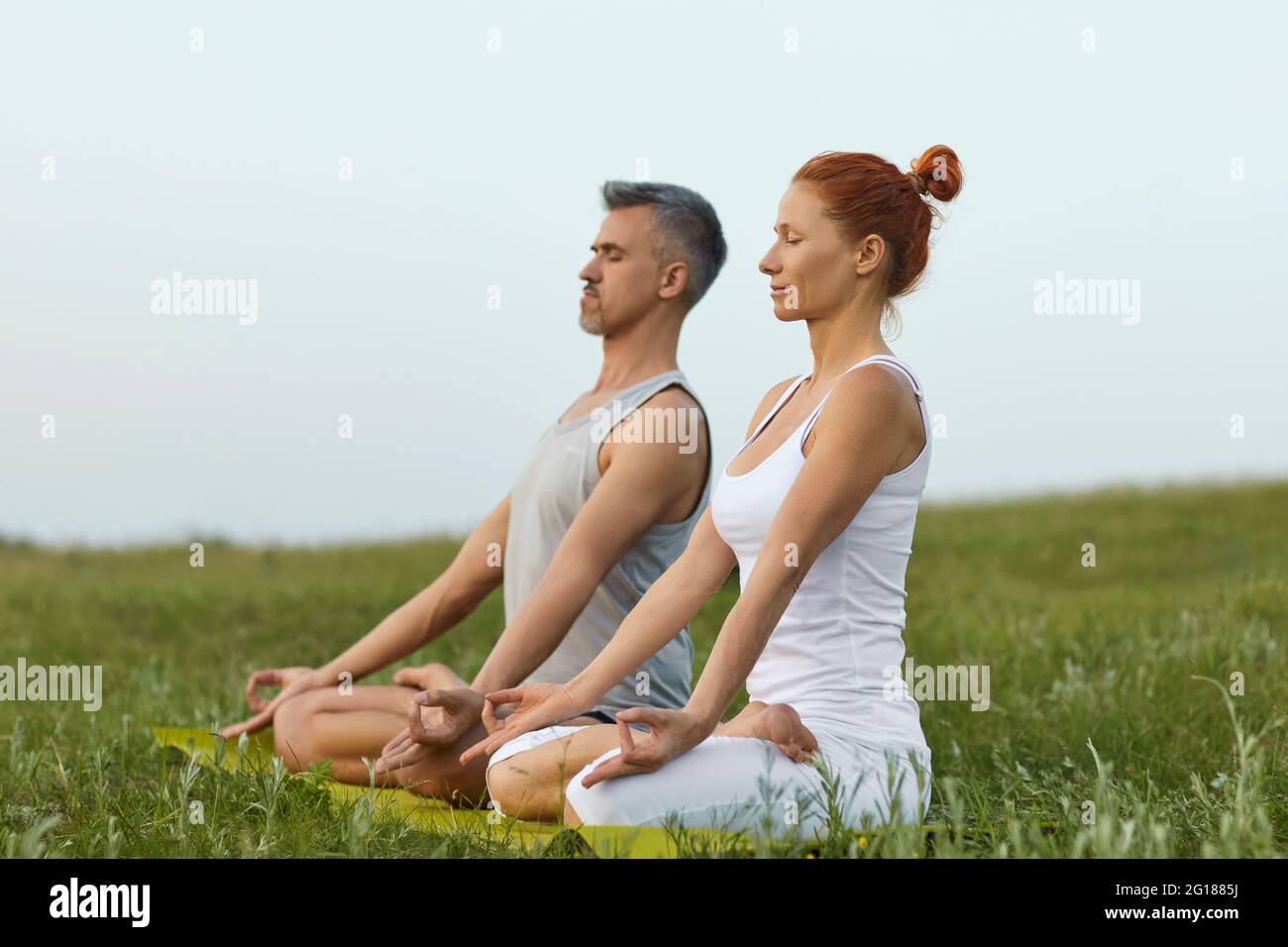Adult couple meditating in summer spring countryside Stock Photo