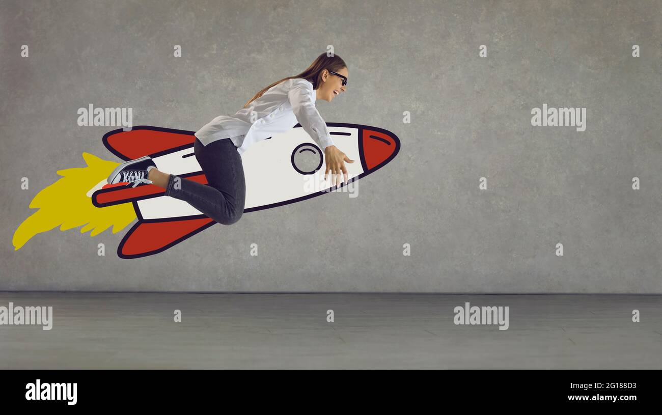 Funny happy crazy girl riding cartoon space rocket as concept of reaching success Stock Photo