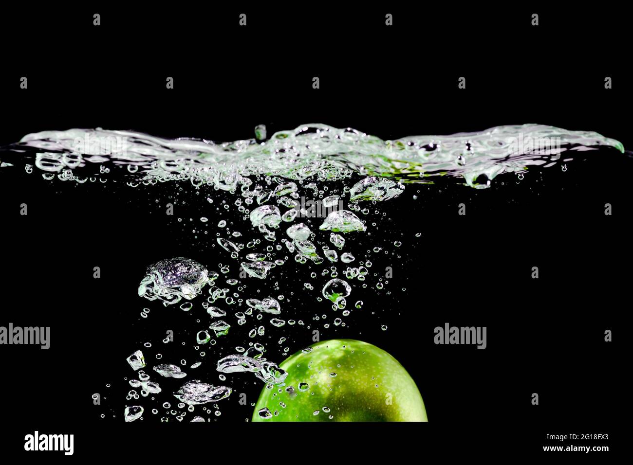 green apple falls into water on black background Stock Photo