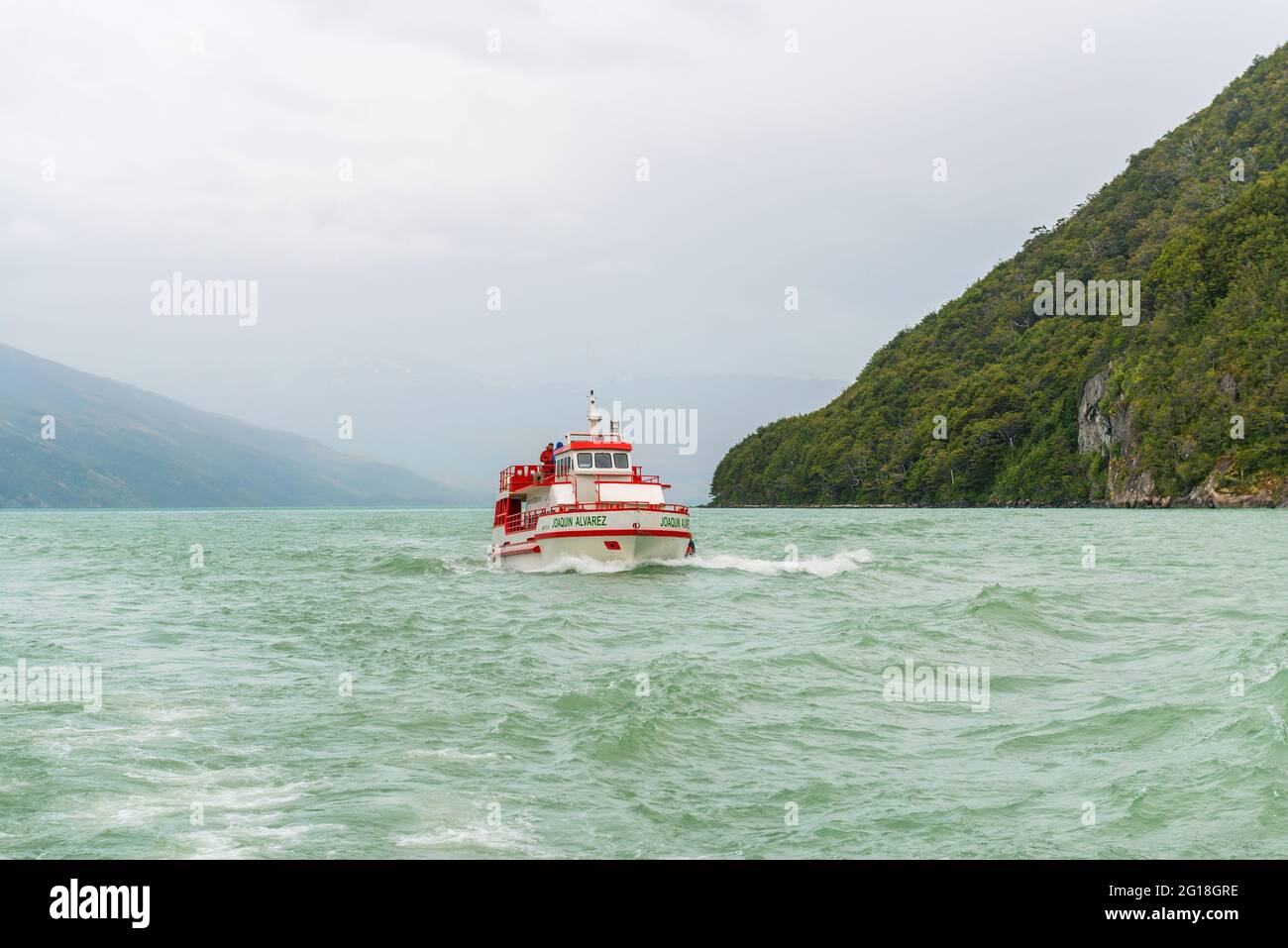 Excursion ferry with tourists sailing in the Last Hope Sound fjord, Bernardo O'Higgins national park, Patagonia, Chile. Stock Photo