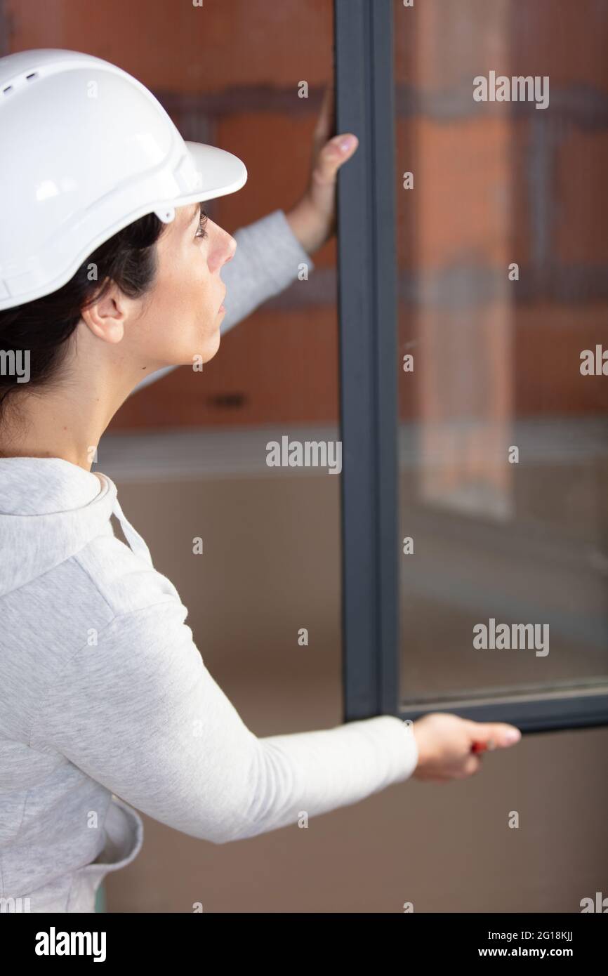 engineer builder woman fixing a window Stock Photo