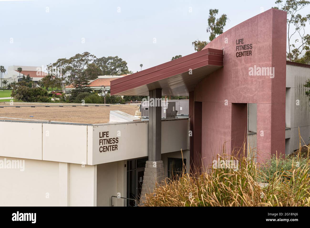 Santa Barbara, CA, USA - June 2, 2021: City College facilities. Life Fitness Center building in beige and red stone. Green foliage and gray sky. Stock Photo