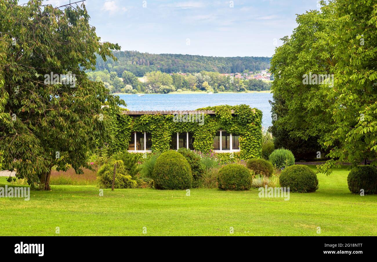 Landscape design with plants and flowers at house in Reichenau Island, Germany. Nice landscaping home garden overlooking Constance Lake (Bodensee). Sc Stock Photo