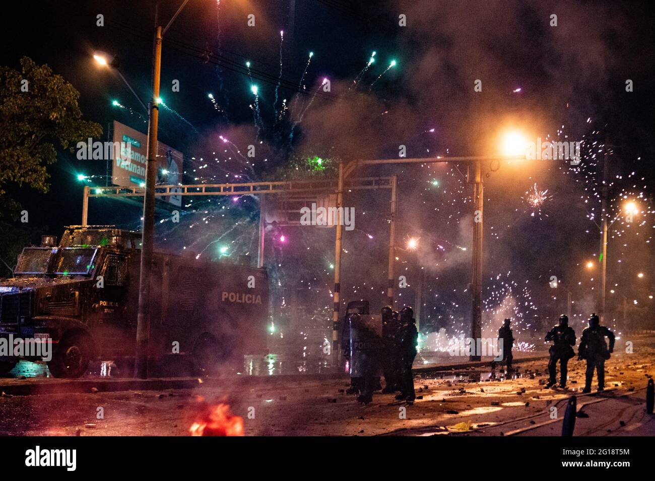 Fireworks used by demonstrators are used to distract and prevent tear gas from being shot by Colombia's riot police (ESMAD) as clashes between demonstrators and Colombia's riot police (ESMAD) erupt in Medellín, Colombia after several weeks of anti-government protest against President Ivan Duque's tax and health reforms and unrest and abuse of authority cases that leave at least 70 dead according to NGOs on June 4, 2021. Stock Photo