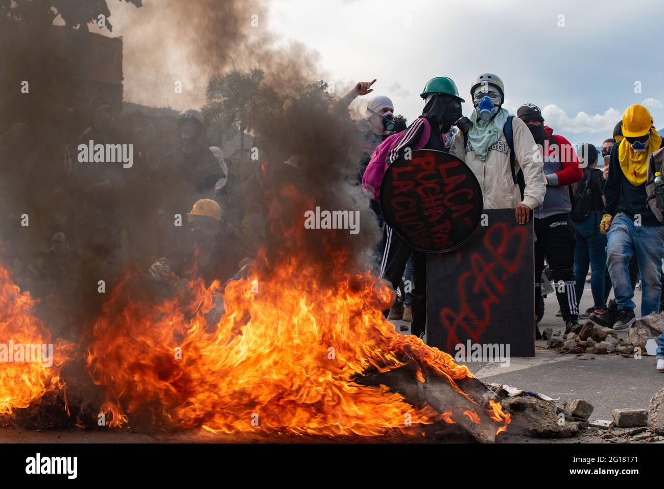 Members of the front line burn tires and debree to prevent the effects of tear gases as clashes between demonstrators and Colombia's riot police (ESMAD) erupt in Medellín, Colombia after several weeks of anti-government protest against President Ivan Duque's tax and health reforms and unrest and abuse of authority cases that leave at least 70 dead according to NGOs on June 4, 2021. Stock Photo