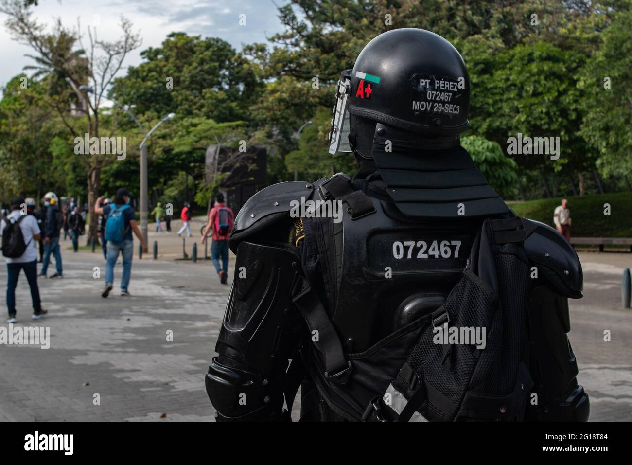 A Colombian Riot Police (ESMAD) officer seen from the back as clashes between demonstrators and Colombia's riot police (ESMAD) erupt in Medellín, Colombia after several weeks of anti-government protest against President Ivan Duque's tax and health reforms and unrest and abuse of authority cases that leave at least 70 dead according to NGOs on June 4, 2021. Stock Photo