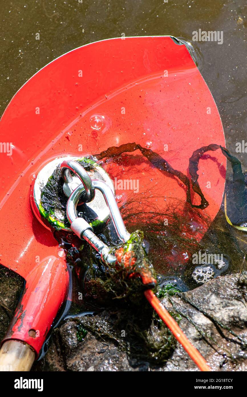 Grebenstein, Germany. 05th June, 2021. ILLUSTRATION - A bucket hangs from a  rope when fishing with a magnet in the Werra. In this special type of  fishing, a magnet is attached to