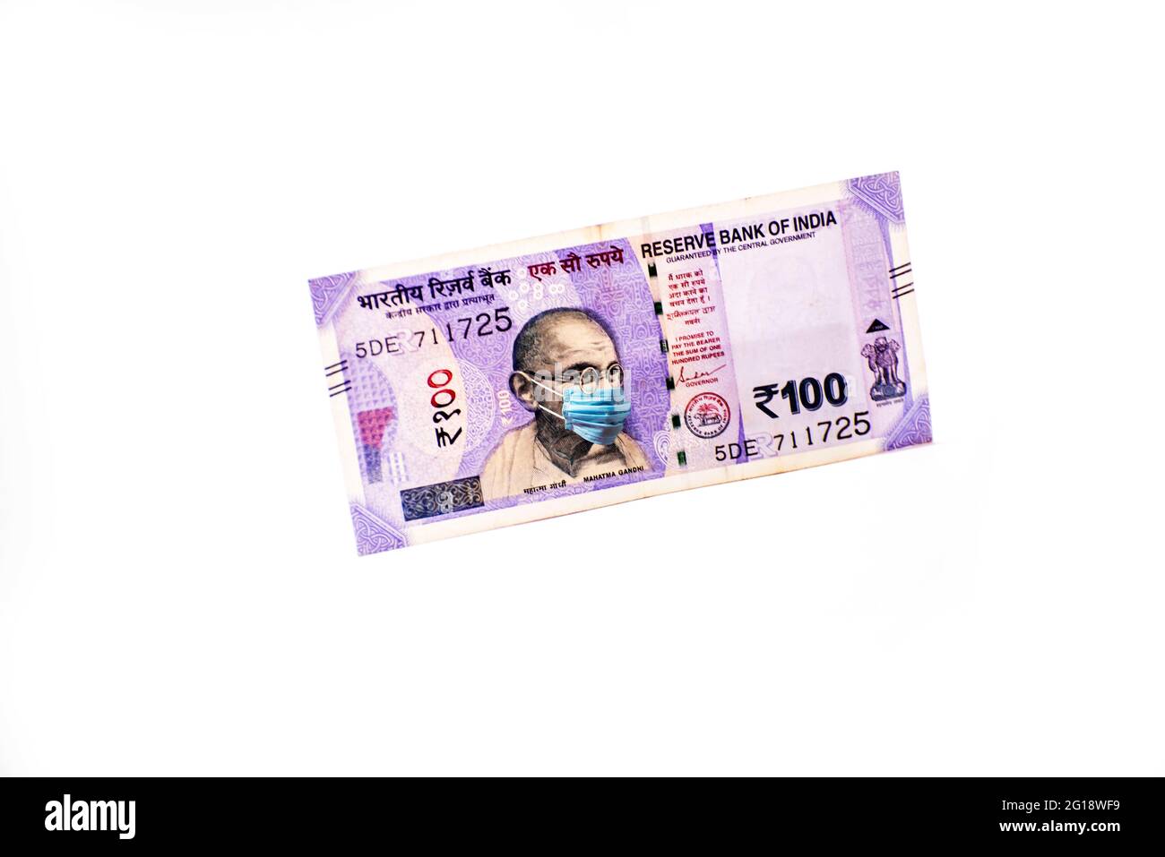 Mahatma Gandhi with face mask against Coivd-19 infection. Global economy hit by corona virus outbreak. Stock Photo