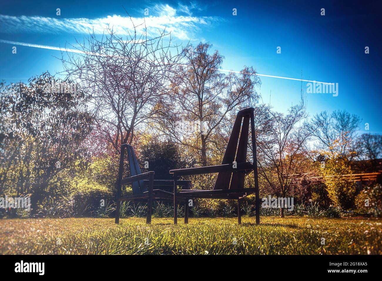 Zwei Stühle, eine Meinung! - Gartenstühle Parkbank, Sitzplätze mitten im Park im botanischen Garten in Duisburg - Sommer im botanischen Garten Stock Photo