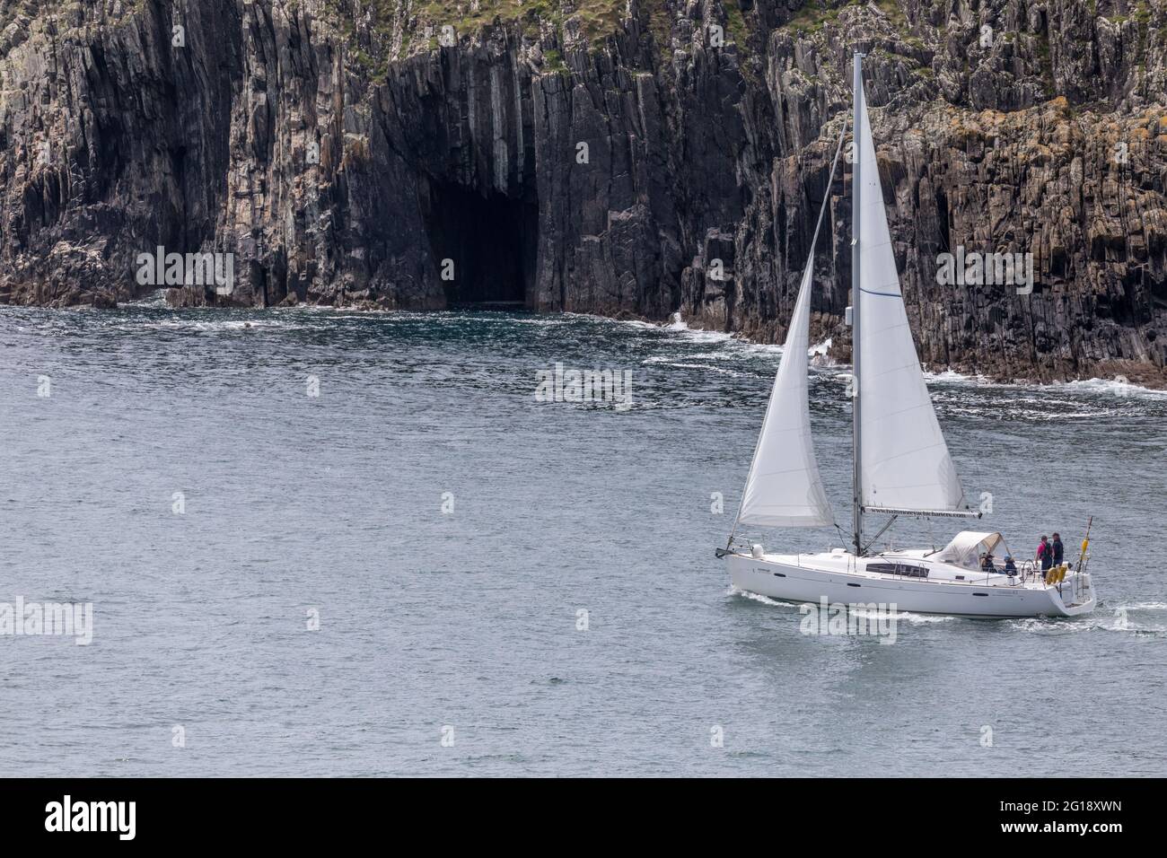 Baltimore, Cork, Ireland. 05th June, 2021. The yacht Inisleigh sails out under full canvas aroud the jagged coastline outside Baltimore Harbour in West Cork, Ireland. -Credit; David Creedon / Alamy Live News Stock Photo