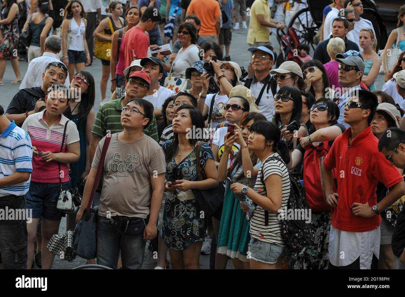 Asian tourists admire the statuary displayed in the Loggia dei Lanzi outdoor sculpture gallery in Piazza della Signoria, the historic heart of Florence, regional capital of Tuscany, Italy.  Sculpture housed in the Loggia includes works by Renaissance artists such as Benvenuto Cellini and Giambologna as well as the 19th century Romantic era sculptor, Pio Fedi. Stock Photo