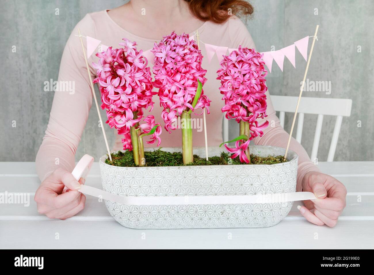Florist at work: How to make beautiful table decoration with pink hyacinth flowers. Step by step, tutorial. Stock Photo