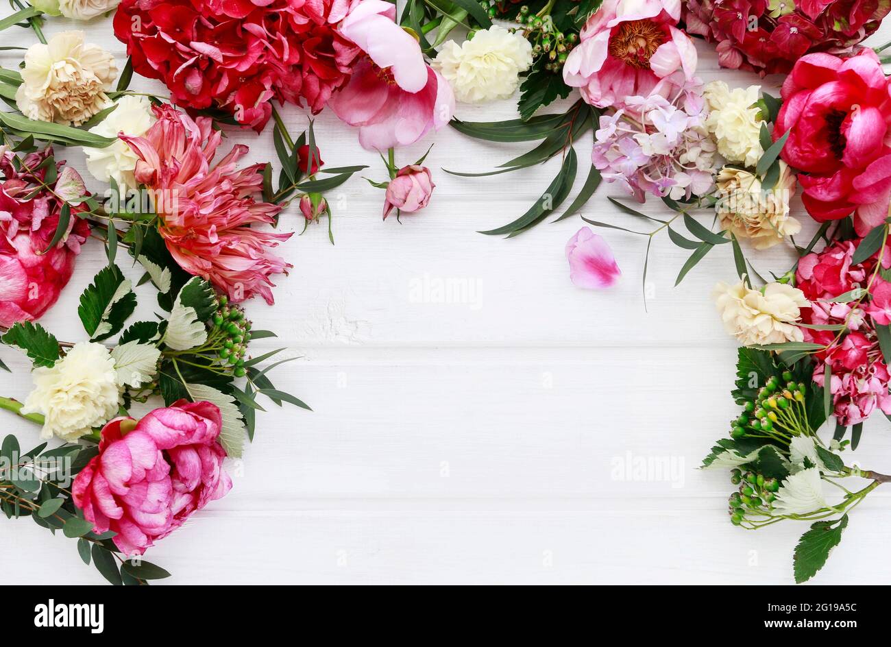 Romantic flower ornament with rose, dahlia, hortensia and carnation flowers. Wooden background, copy space. Stock Photo