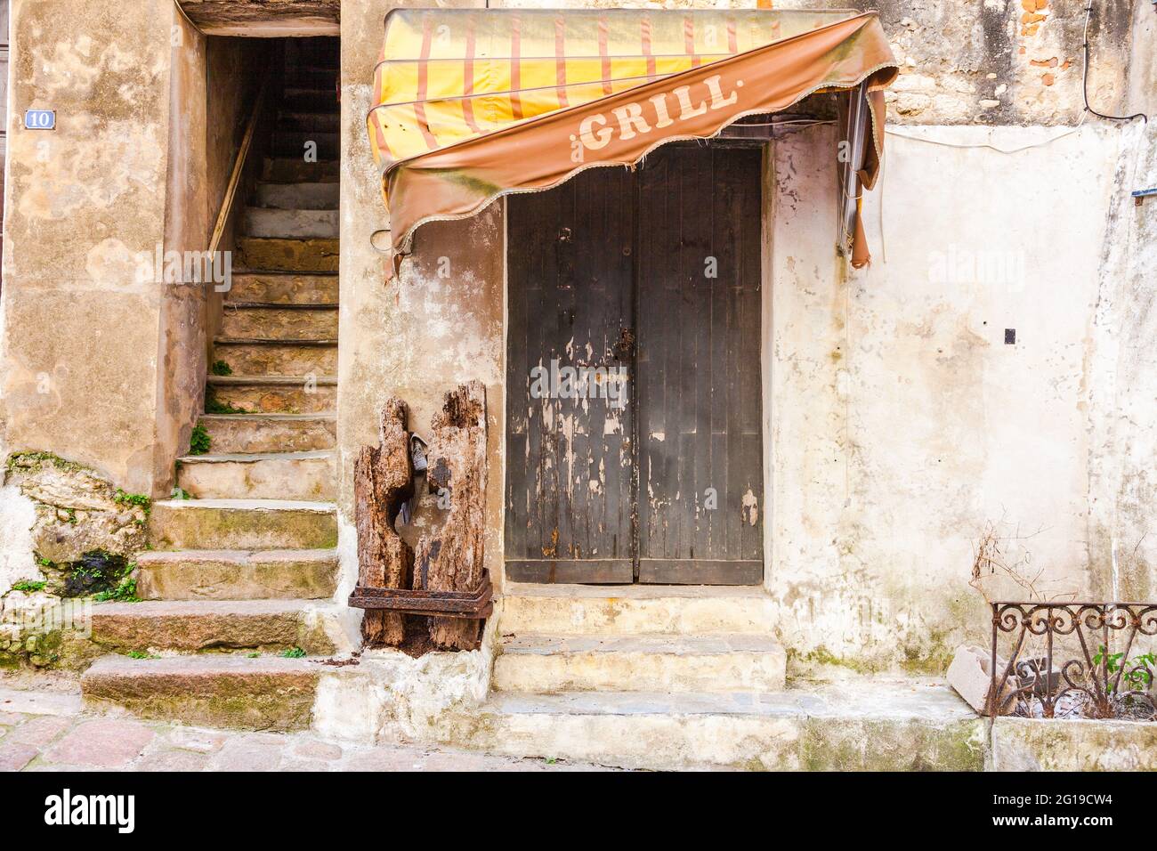 Dilapidated awning, bearing the ad 'grill', vestige of a derelict restaurant. Bonifacio, Corsica, France Stock Photo