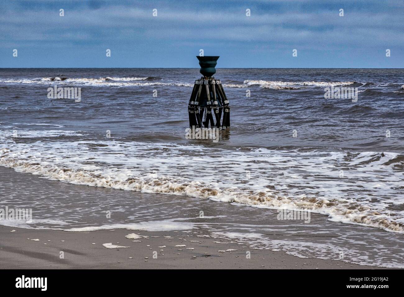 The time and tide bell in the North Sea at Mablethorpe, Lincolnshire, by artist Marcus Vergette. Stock Photo