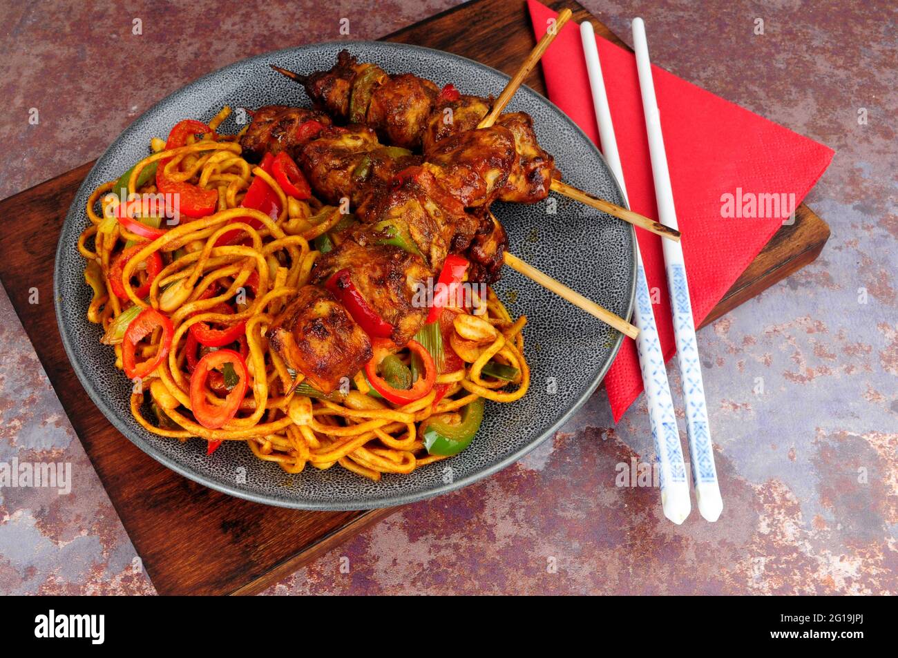 Sweet chilli chicken skewers with egg noodle stir fry Stock Photo Alamy
