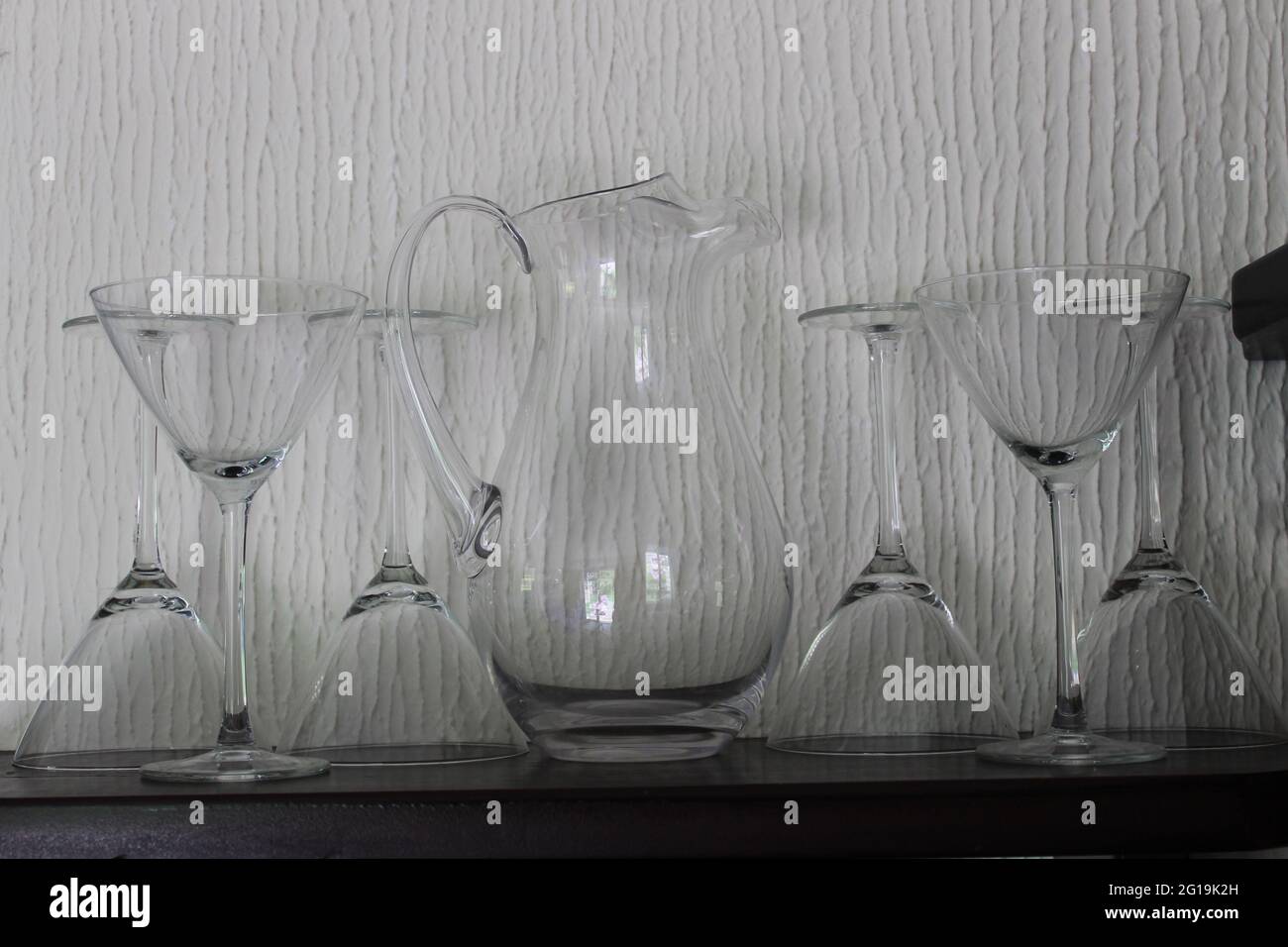 Glass jug and cocktail glasses on a shelf Stock Photo Alamy