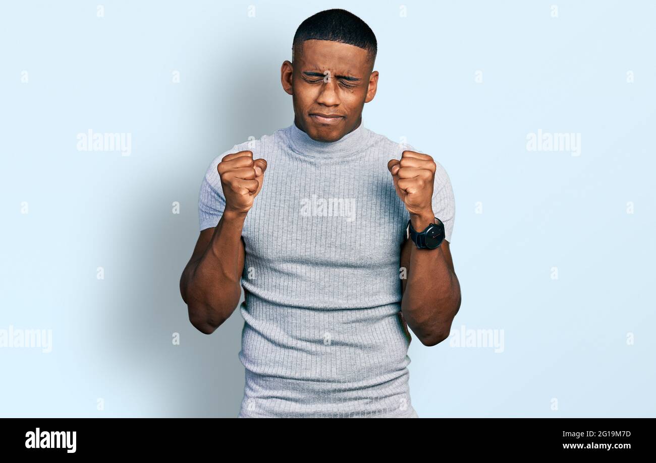 Young black man wearing casual t shirt excited for success with arms ...
