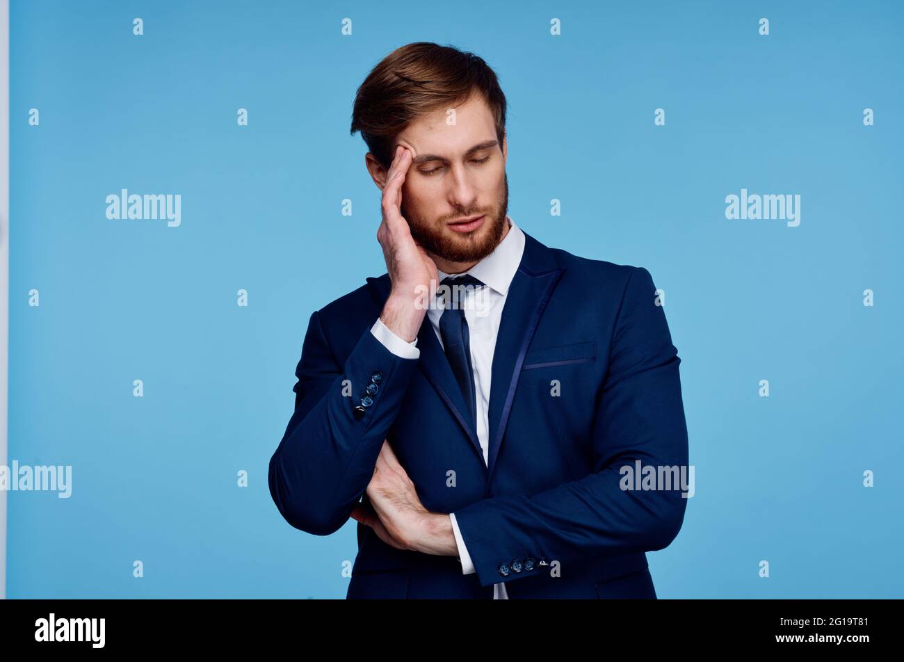 business man in a suit holds his hand near his head displeasure blue ...