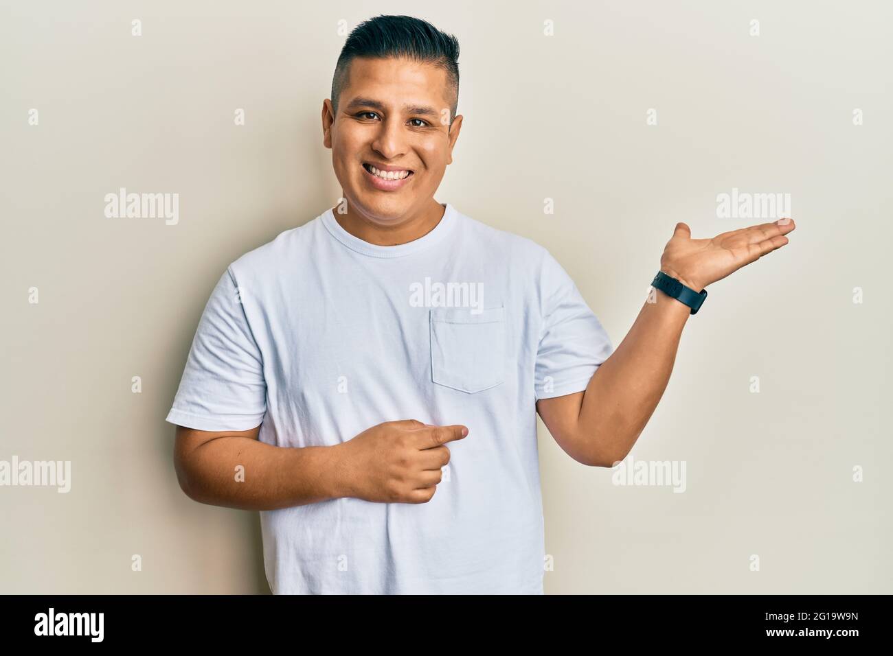 Young latin man wearing casual white t shirt smiling cheerful ...