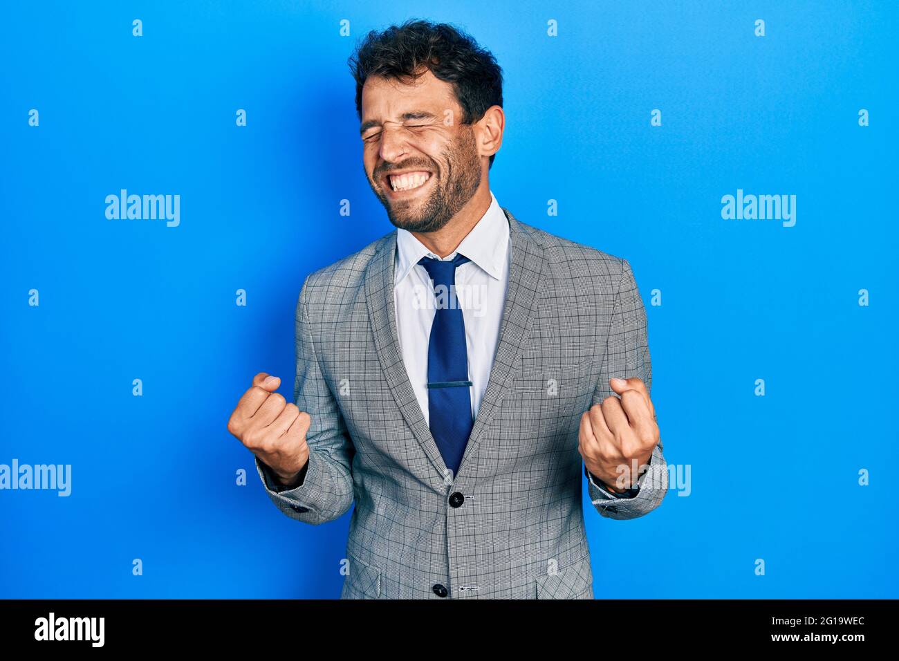 Handsome man with beard wearing business suit and tie excited for ...