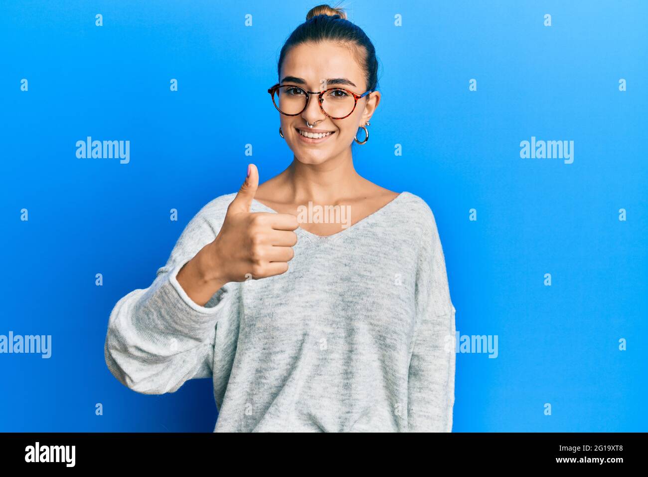 Young hispanic woman wearing casual clothes doing happy thumbs up ...