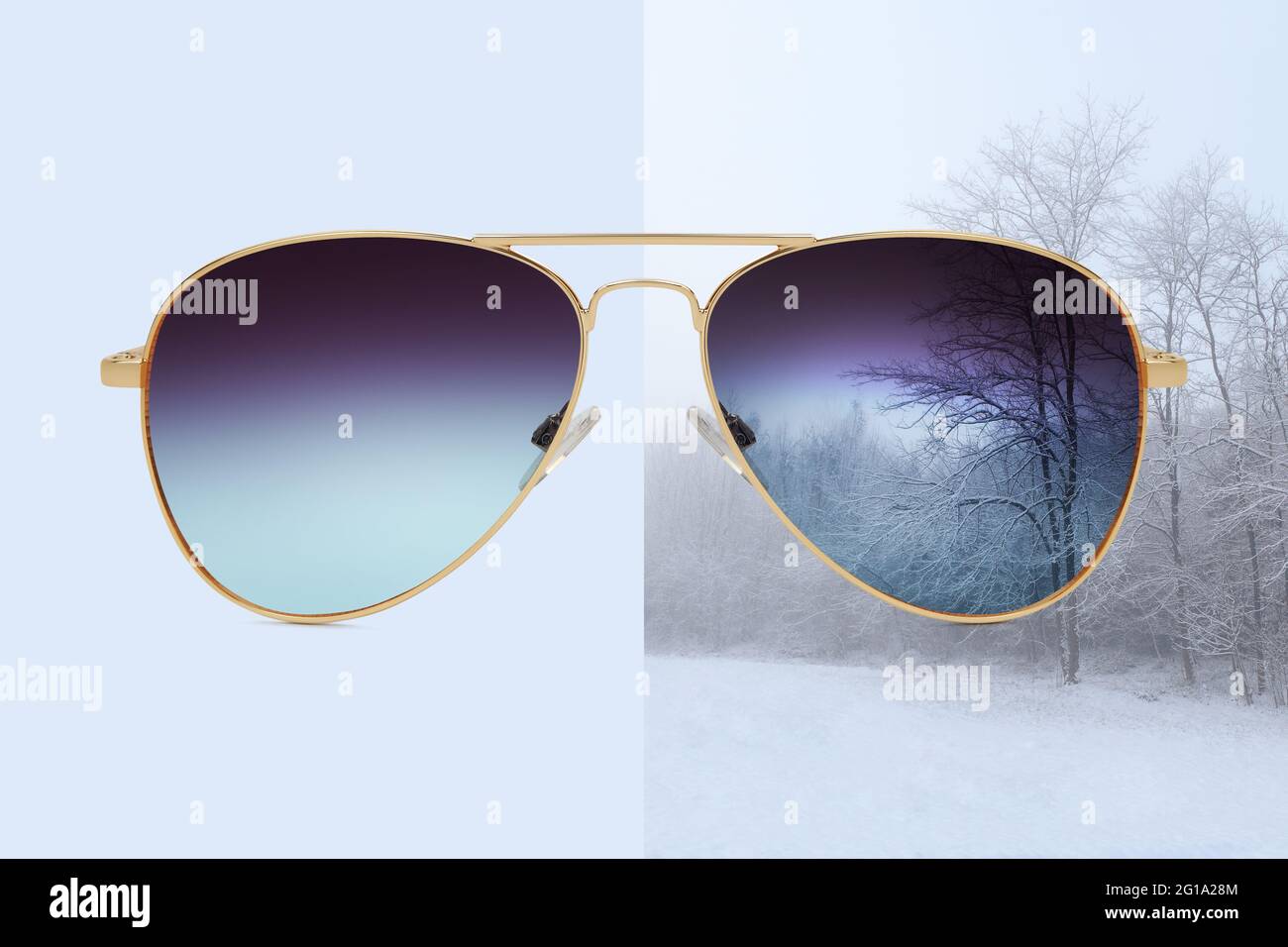 aviator sunglasses isolated on blue and winter background with snow covered trees, concept of polarized protective lenses Stock Photo