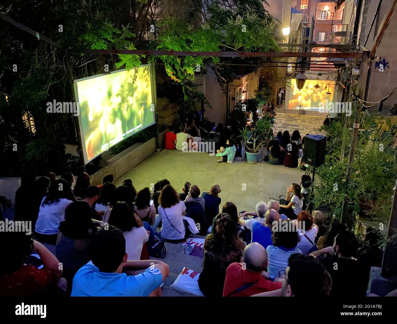 People watch a movie during the opening of the 13th edition of Cabriolet  Film Festival, as they sit on the steps of Gemmayze's Saint Nicolas stairs,  an area that was damaged in