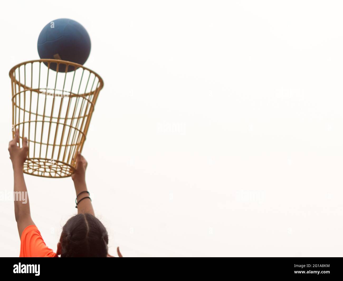 A girl in a basket holding position in a school chair-ball game Stock Photo