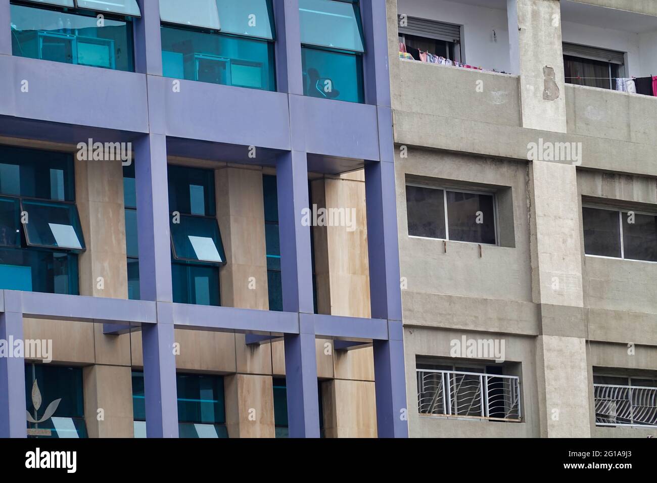 The facade of a modern building and an old building next to each other ...