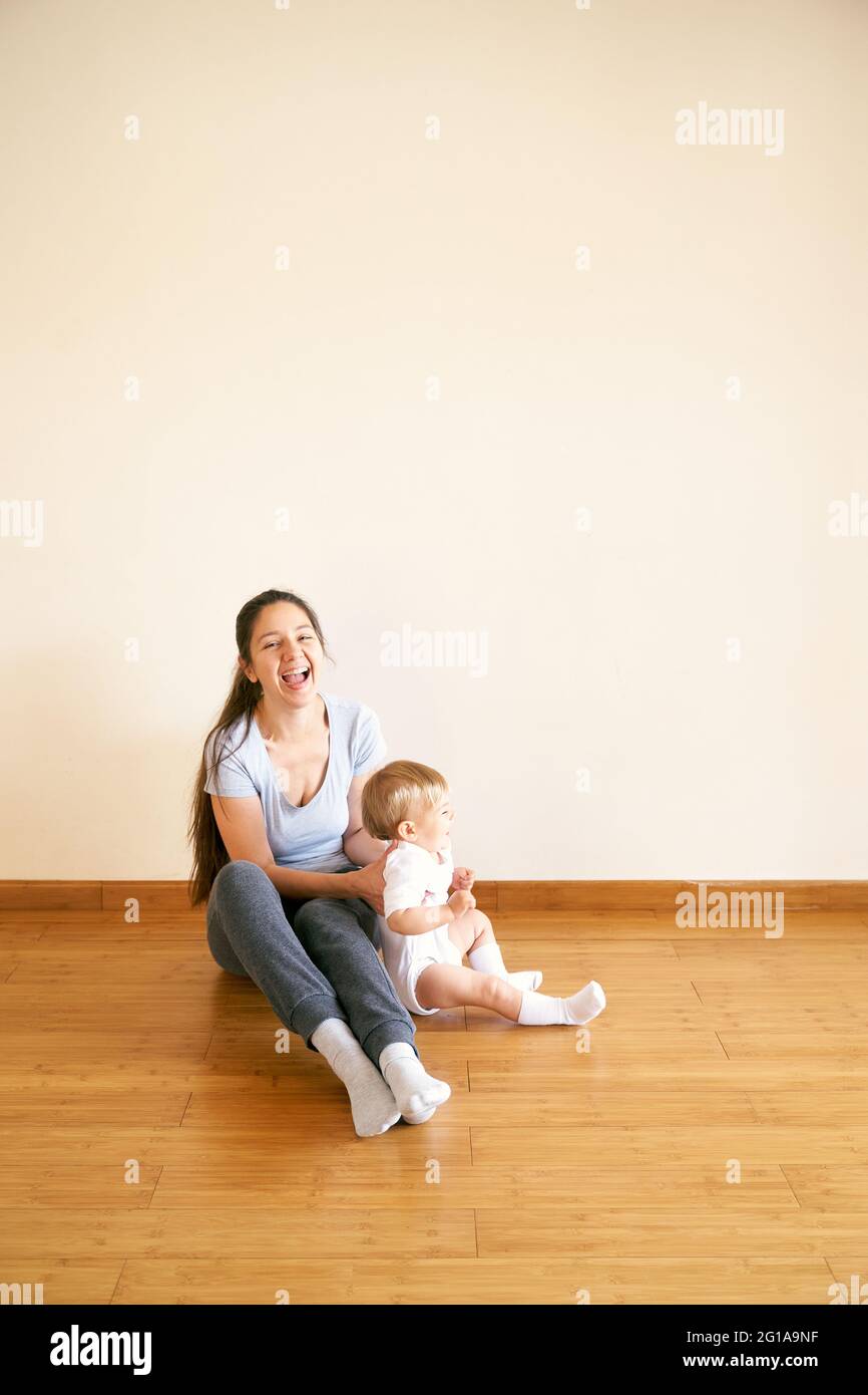 Smiling mom and little girl sitting on the floor Stock Photo - Alamy