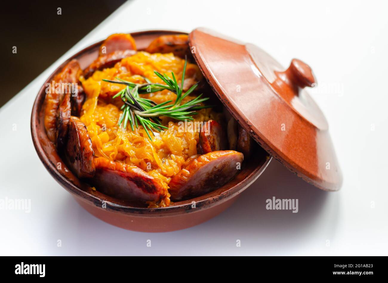 Traditional Polish dish called bigos made of sauerkraut, sausage and mushrooms, food served warm in a ceramic bowl, Eastern European food Stock Photo