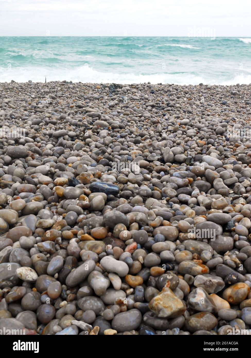 Natural colored pebbles and blue ocean Stock Photo