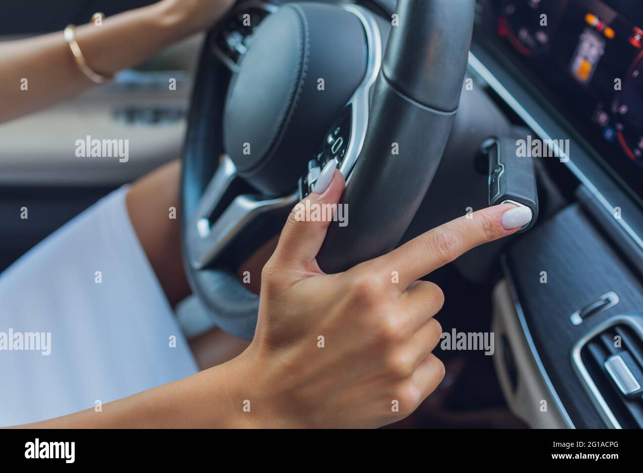 Woman's hand switches the lobes of the gear selector on the steering