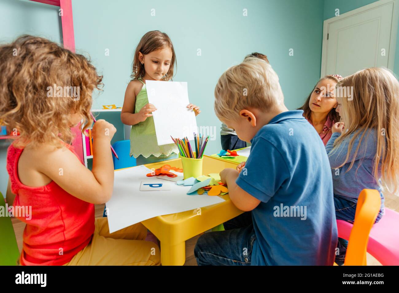 Happy little girl showing her drawing to the camera Stock Photo - Alamy