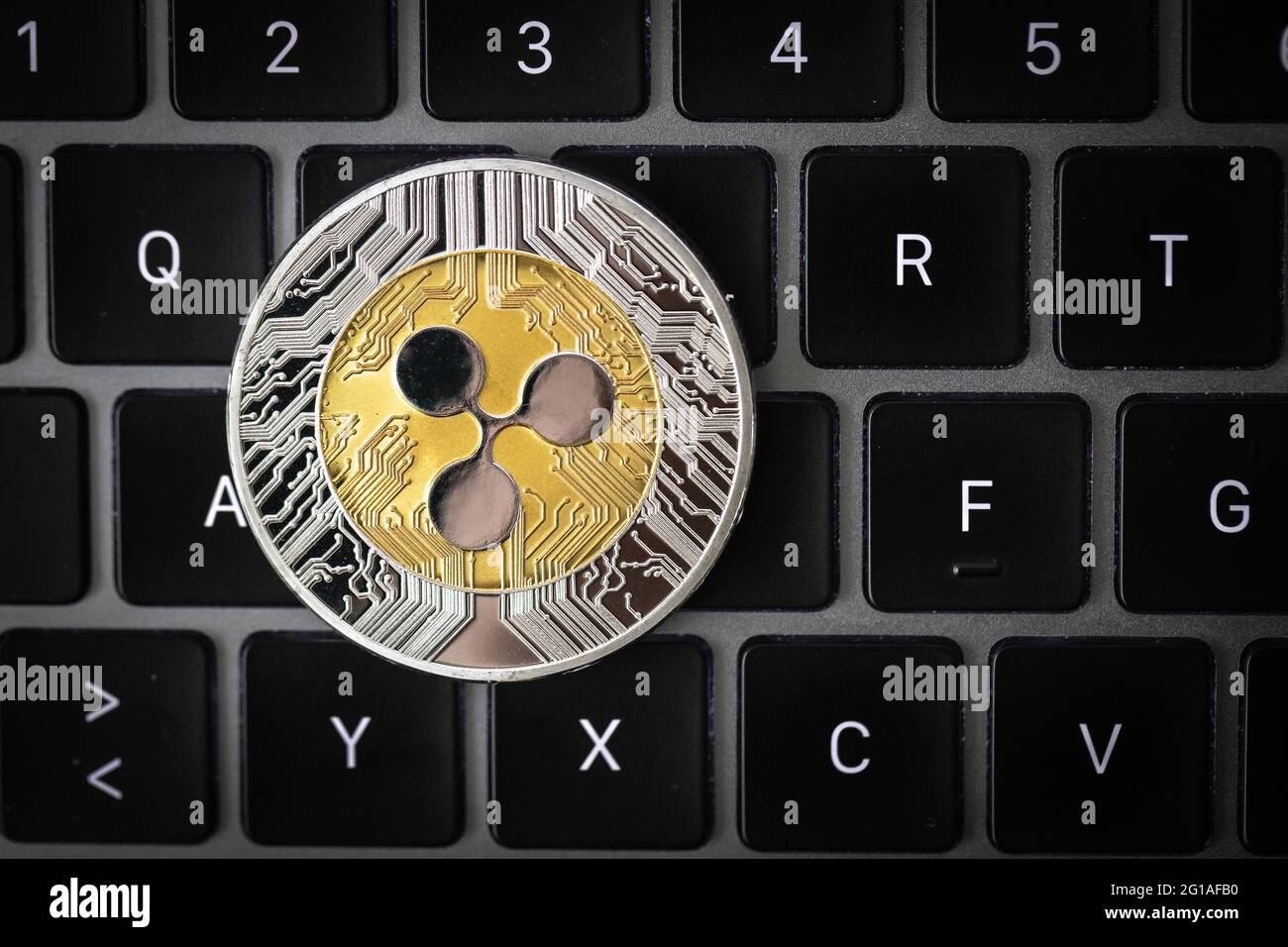 Ripple cryptocurrency physical coin laying on a laptop keyboard. Stock Photo