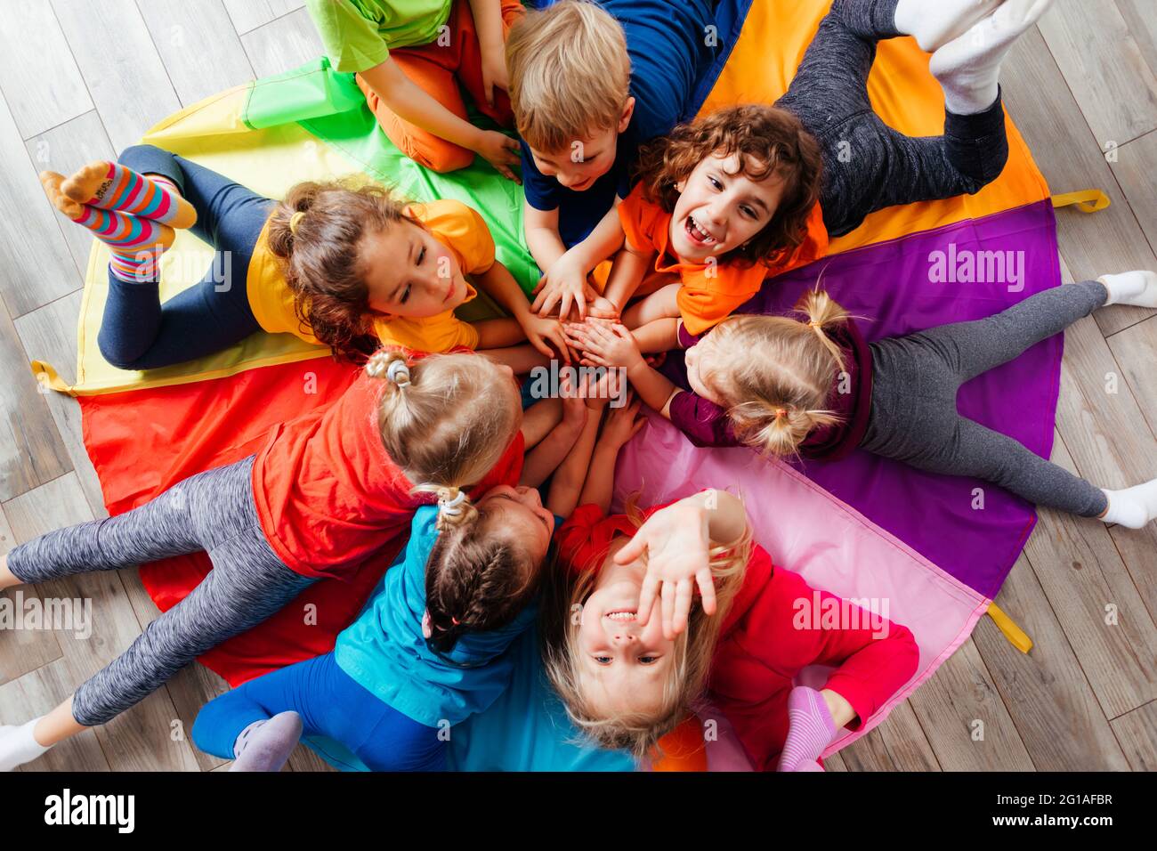 Cheerful children playing team building games on a floor Stock Photo