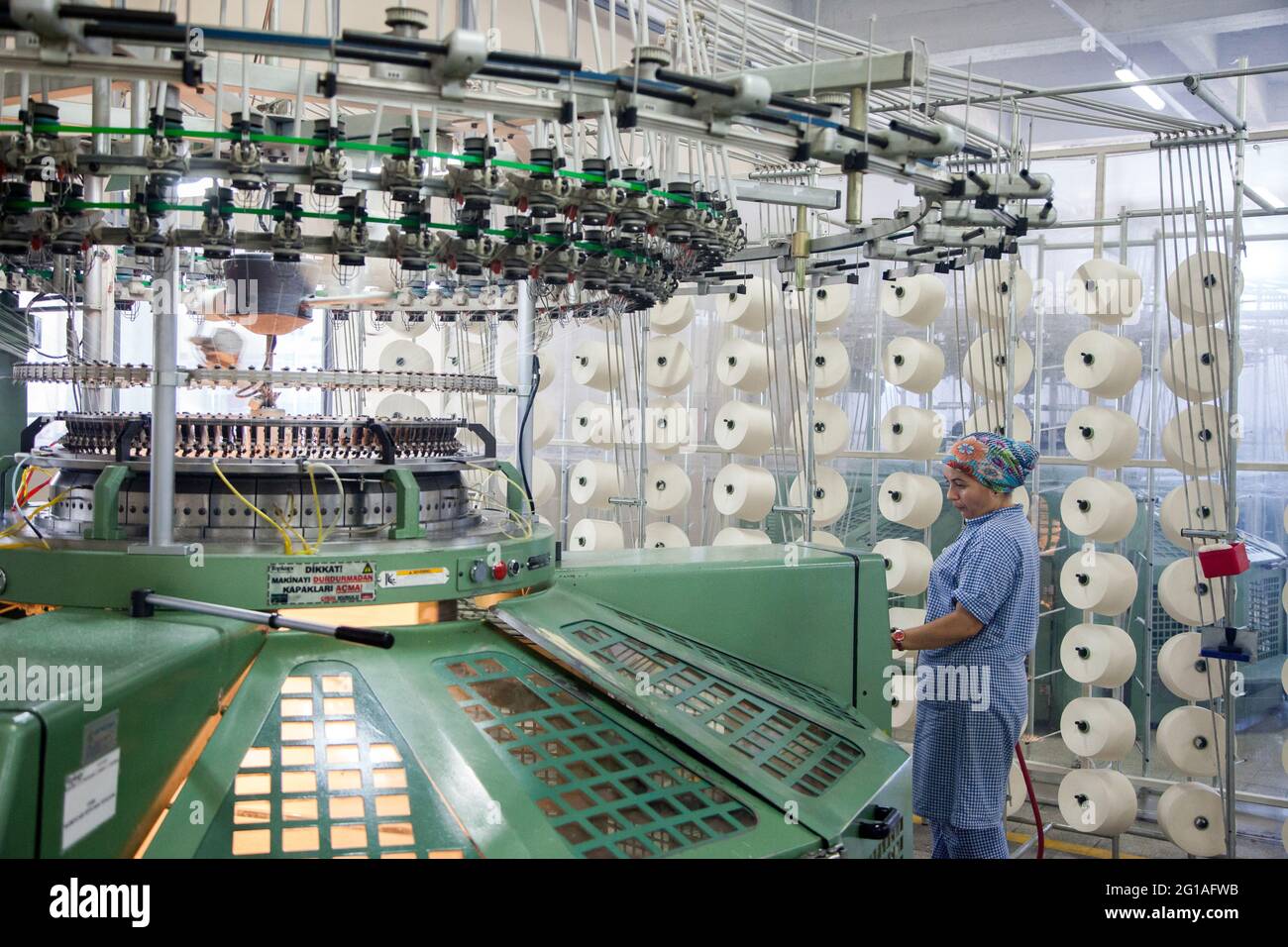Istanbul/Turkey - 08-26-2014: An unknown female worker works in a factory that produces cotton yarn. Stock Photo