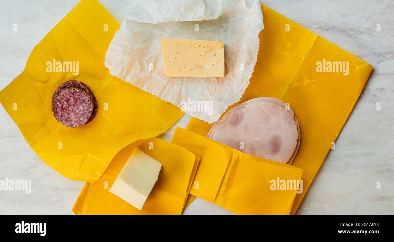 Cheese, salami and ham slices wrapped into beeswax paper Stock Photo