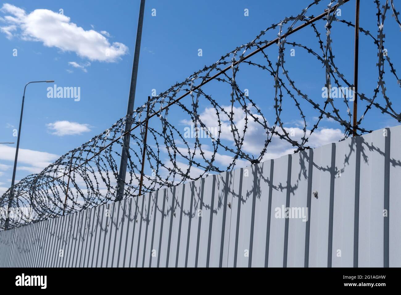 Metal fence with barbed wire on the background of the blue sky Stock ...
