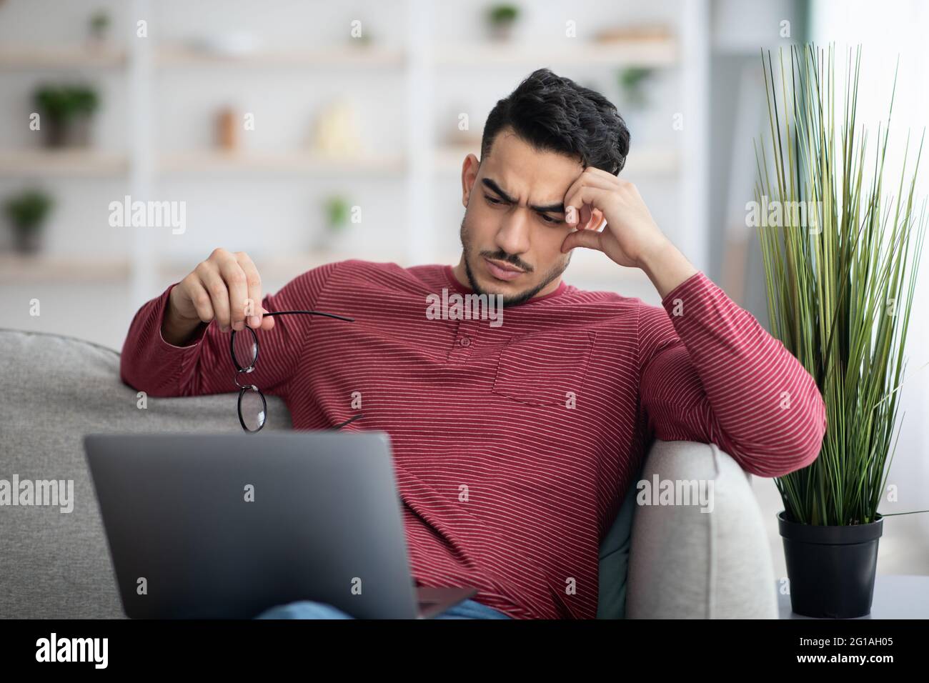 Pensive arab man working on laptop, looking for solution Stock Photo