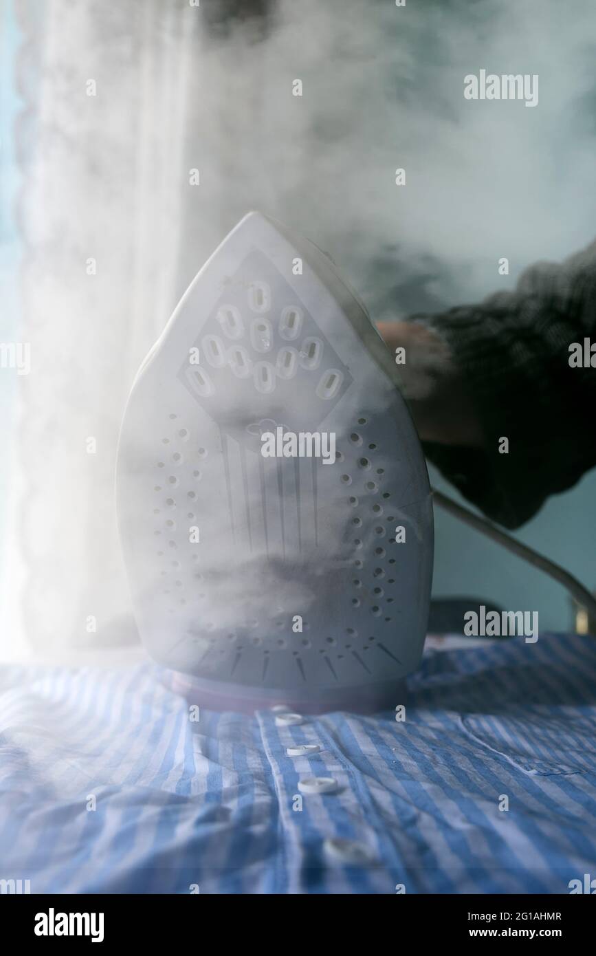 ironing a shirt with a steam iron Stock Photo Alamy