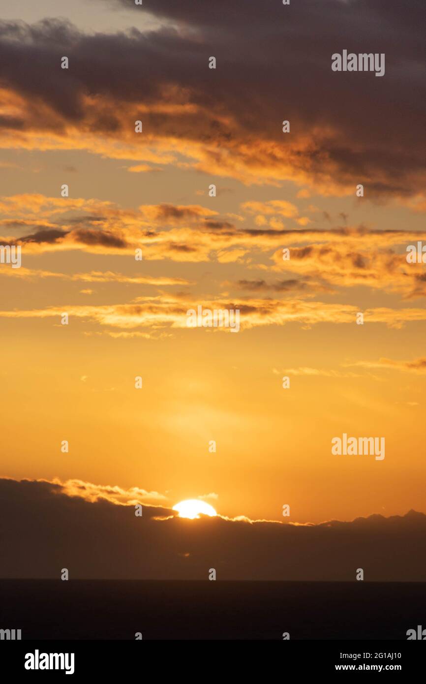 A dramatic sunset over the ocean with colorful skies and color being ...
