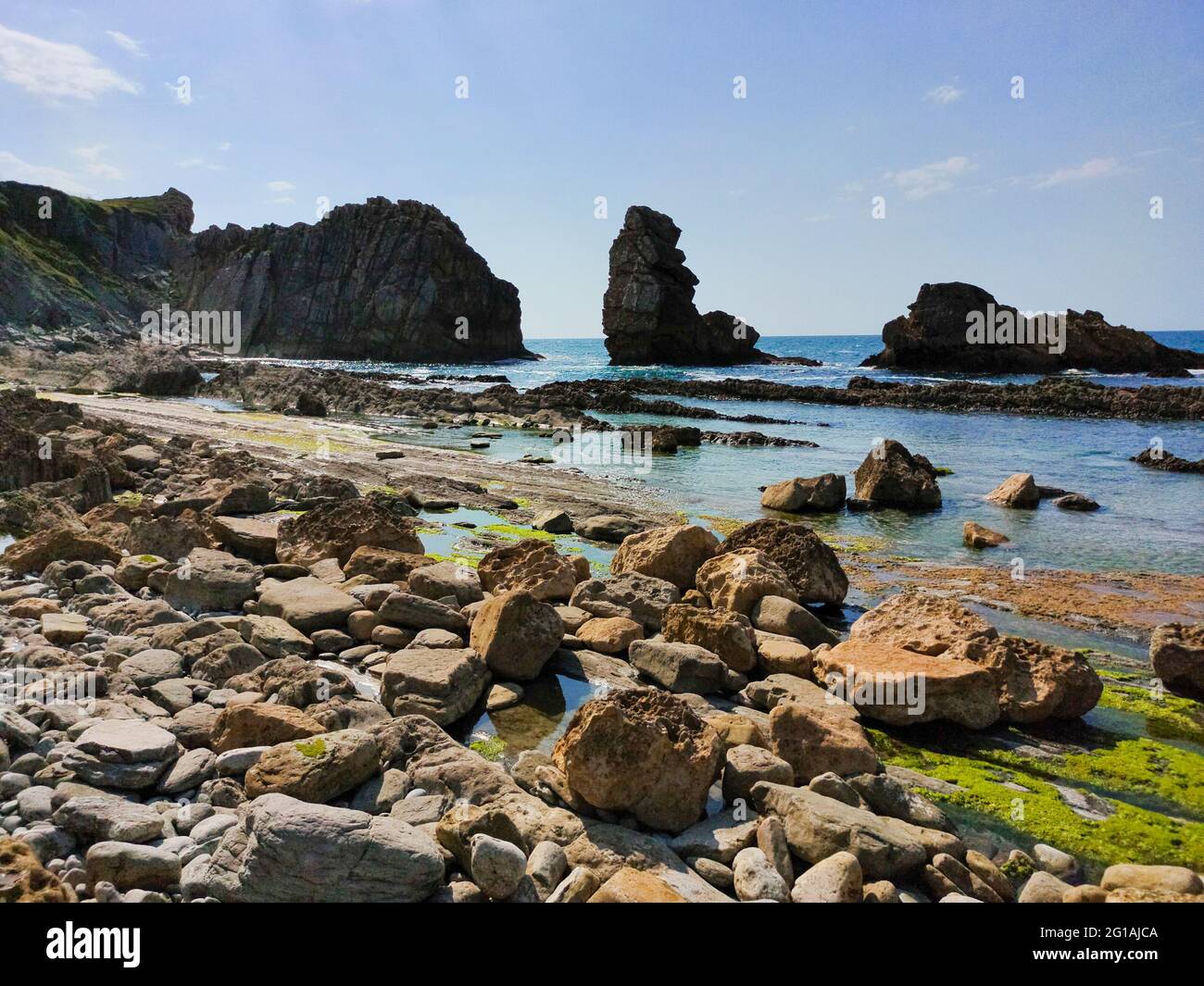 Aa rocky beach and the blue sea on a sunny day Stock Photo - Alamy