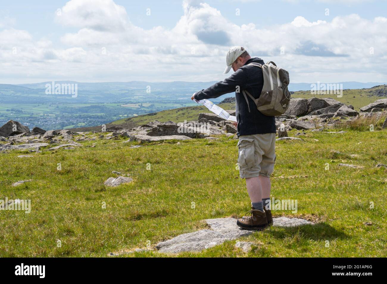 Dartmoor National Park, Devon, UK. 6th June, 2021. UK Weather: Warm sunny spells on Dartmoor. A walker checks his map near Great Staple Tor. Credit: Celia McMahon/Alamy Live News Stock Photo