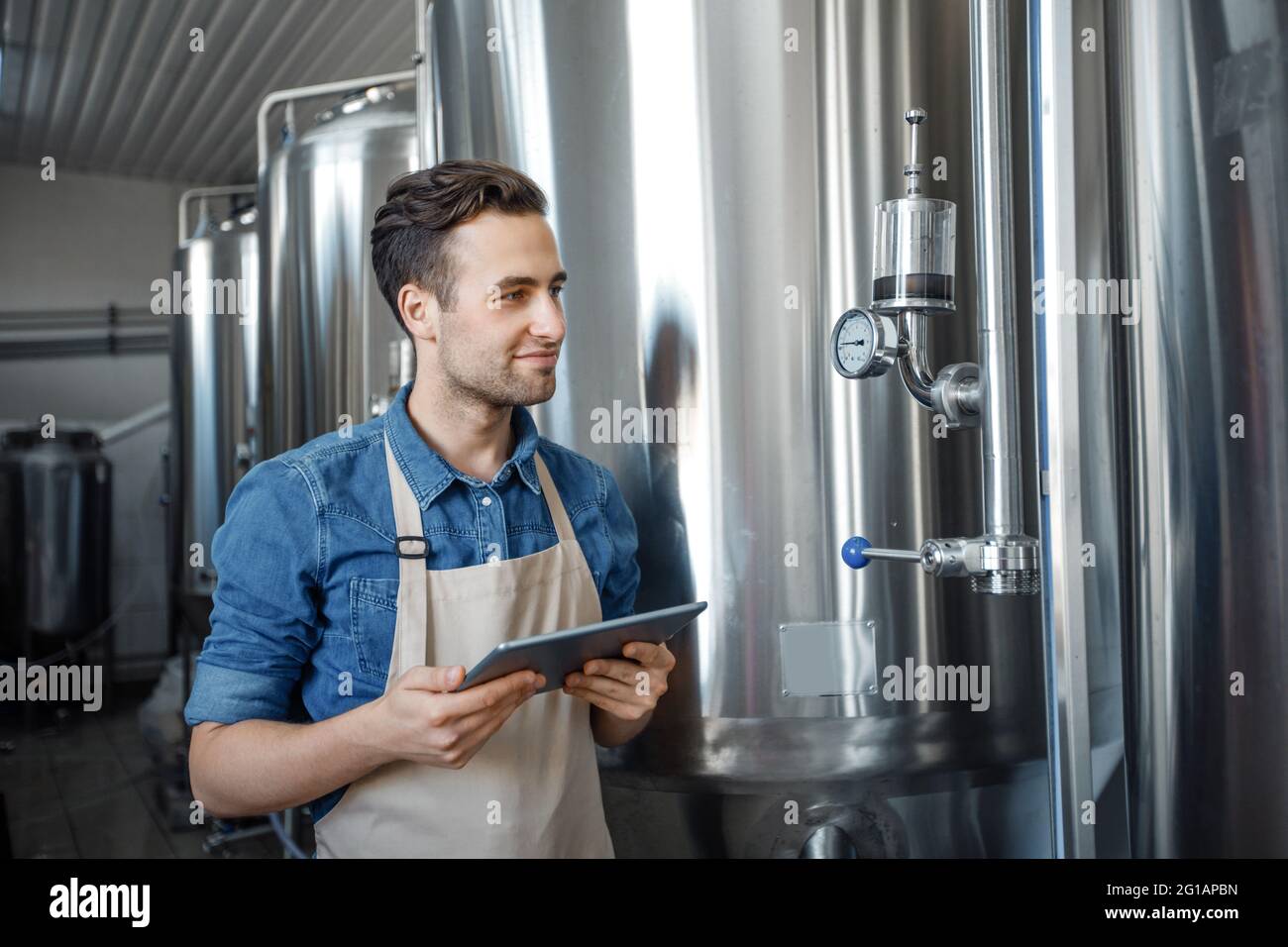Traditional craft beer production at brewery. Smart manufacture and management of modern gadgets Stock Photo