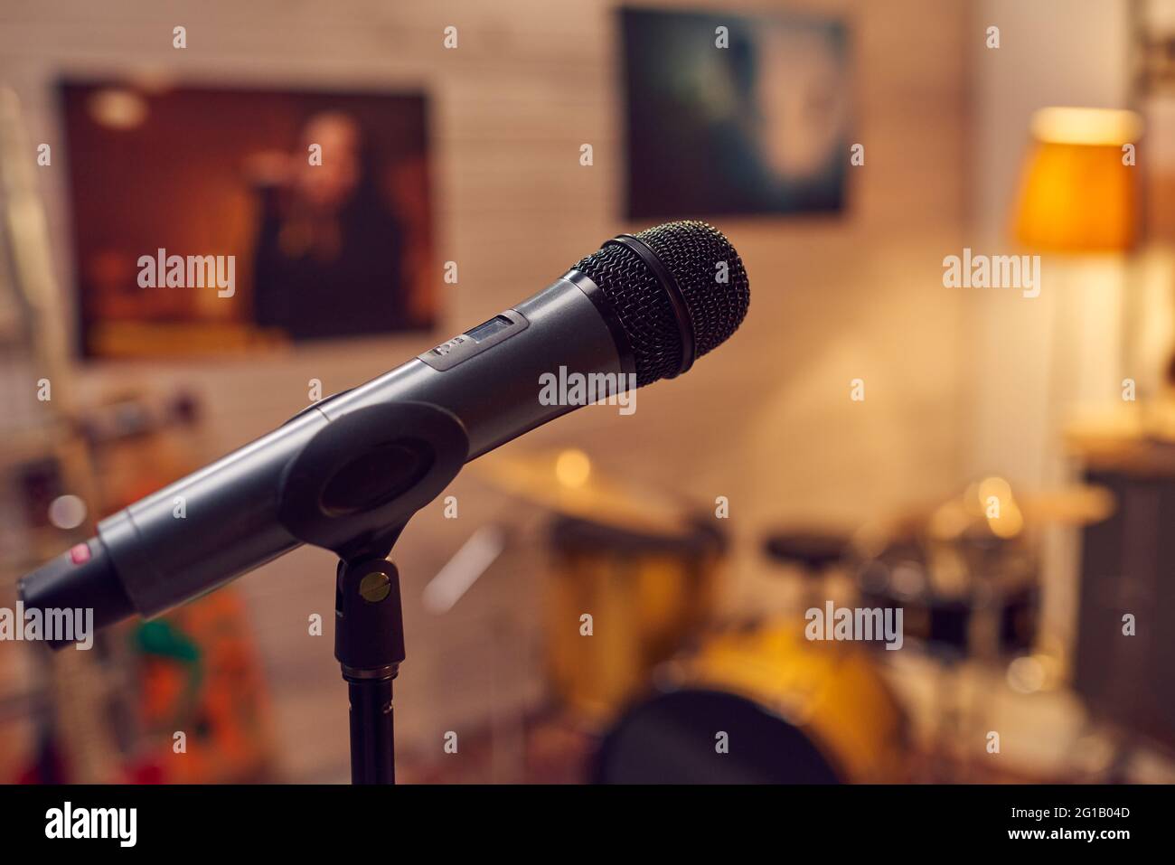 Black microphone against posters of popular modern female musicians Stock Photo