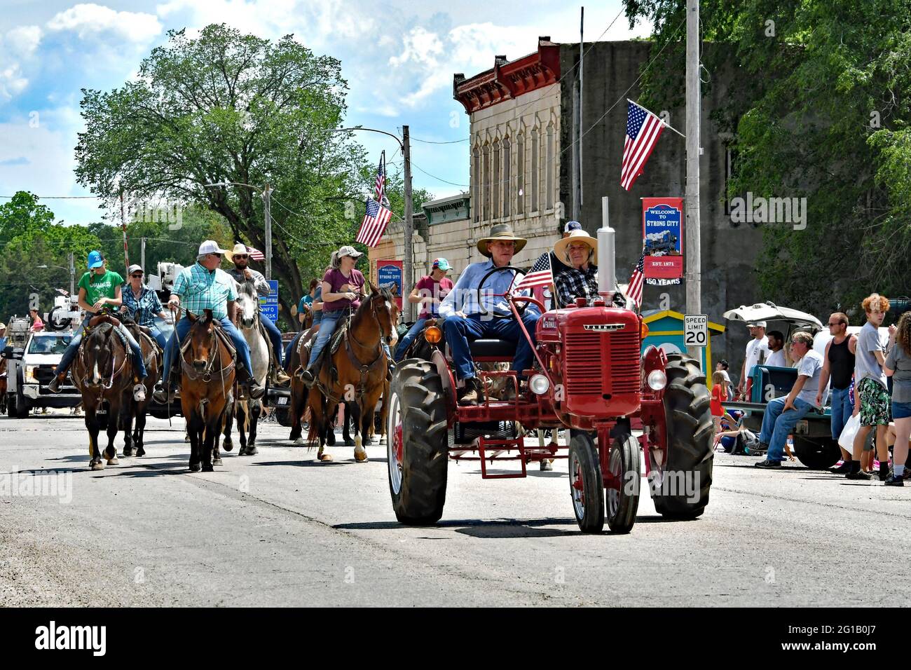 Elderly local farmer drives his 1939 Farmall model H tractor leading a