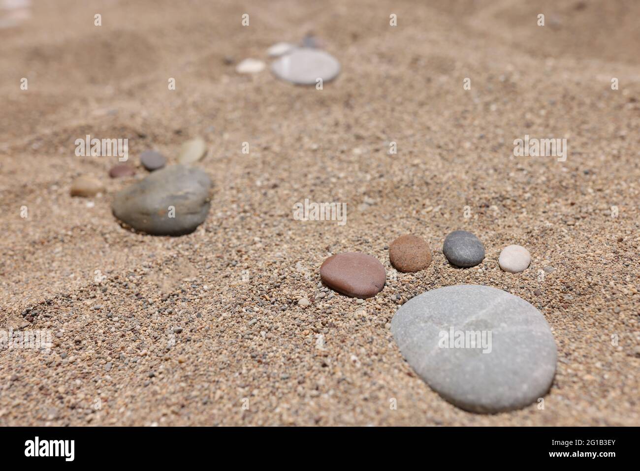Feet are made of stones on beach sand Stock Photo Alamy